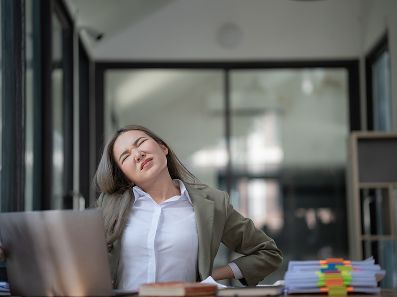 Woman at desk with lower back pain